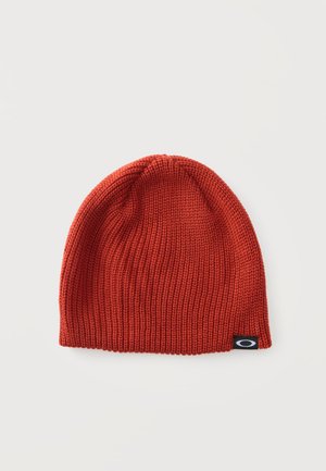 Bonnet en laine rouge avec une petite étiquette noire présentant un logo ovale blanc sur un fond blanc uni.