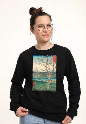 Felpa nera con stampa frontale di un'opera che raffigura un albero e un paesaggio con montagne e acqua. Materiale in cotone, vestibilità rilassata.