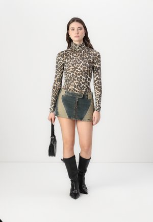 Top med leopardmønster og lange ærmer, mini-nederdel med blågrønne paneler, sorte støvler til lårene med spids tå og en lille sort håndtaske.