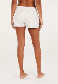 Shorts bianchi in cotone con vita elasticizzata, caratterizzati da una tasca posteriore e un piccolo logo vicino alla vita. Tessuto morbido, vestibilità casual.