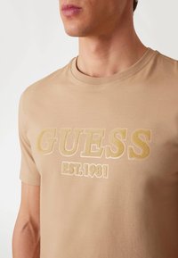 Guess LOGO BEFLOCKUNG - Marškinėliai su spaudiniu - hellbraun