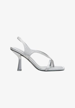 Sandales à talons hauts argentées avec une sangle ornée de strass, bout ouvert et une fine sangle au niveau de la cheville. Fini en satin lisse.