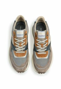 Sneakers da uomo con una miscela di suede grigio, accenti marroni, mesh e pelle nera. Design con lacci e suola in gomma.