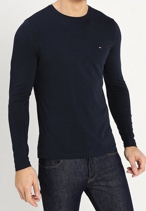 Navyblaues Langarm-T-Shirt aus Baumwolle. Mit einem Rundhalsausschnitt und einem kleinen Logo-Akzent auf der Brust. Einfaches, tailliertes Design.
