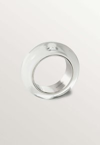 Anillo de vidrio claro con un diseño liso y redondeado, y un pequeño cristal acentuado en la parte superior. Banda interna de metal pulido. Apariencia simple y elegante.