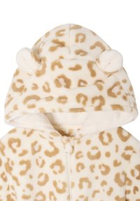 Leopard print onesie in soft beige plush fabric, featuring a hood with rounded ears and a front zip closure. Brown spots throughout.