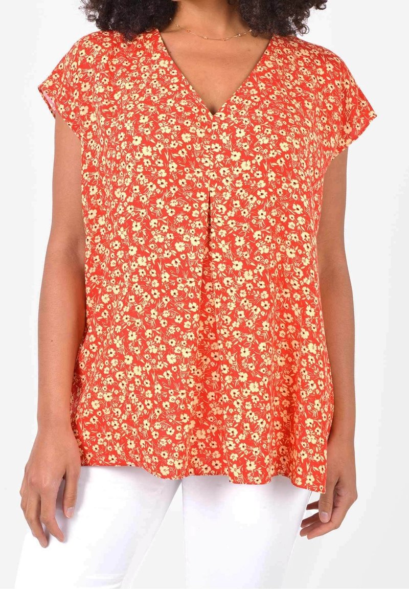 Haut fleuri avec un décolleté en V, manches courtes, en orange vif avec des fleurs jaunes, présentant une coupe ample et une texture de tissu douce.