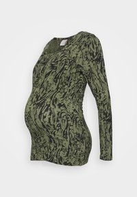 Långärmad graviditetstop i olivgrön med ett svart abstrakt mönster. Har elastiskt tyg och en figurnära silhuett som är designad för komfort.