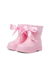Bottes de pluie en caoutchouc rose avec une finition brillante, dotées d'un revers replié et de grands nœuds en satin de chaque côté. Semelle texturée pour une meilleure adhérence.