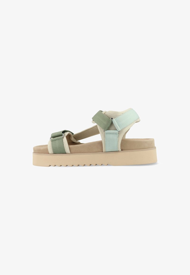 Sandaal met verstelbare mintgroene en crèmekleurige bandjes, een beige platformzool en een gestructureerd oppervlak met een zigzagpatroon aan de onderkant.