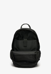 Schwarzer Stoffrucksack mit runder Form, Reißverschlussverschluss, einem oberen Tragegriff und Innenfächern, darunter ein Netzfach.