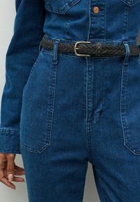 Denim overall u tamnoplavoj boji sa prilagođenim oblikom, s dodatnim džepovima i pletenim crnim kožnim remenom sa mesinganim kopčom.