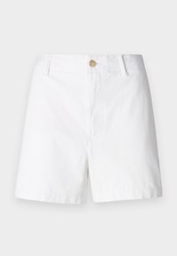 Shorts en coton blanc avec devant plat, deux poches avant et un seul bouton en bois à la taille. L'ourlet se termine au-dessus du genou.