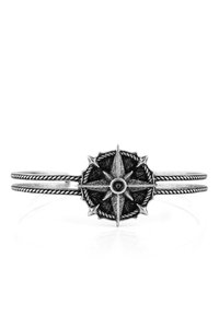 Silver cuff bracelet with a compass design at the center. Features intricate detailing, including a textured black background and double band.