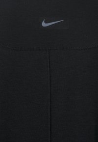 Fekete sportos felső sima anyagból, elöl diszkrét, szürke Nike logóval. Minimalista dizájn sima varrásokkal.