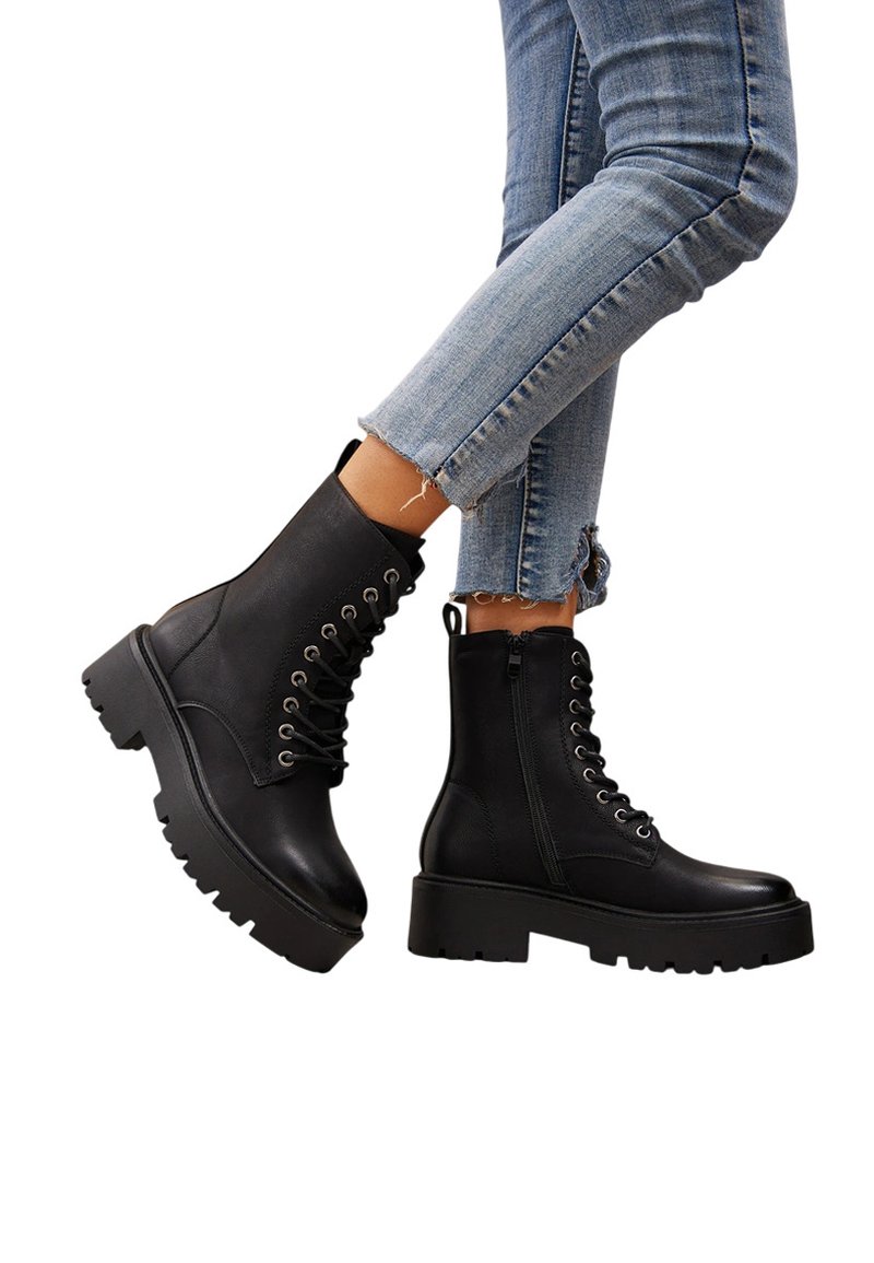 Bottines noires en cuir synthétique avec une semelle épaisse, un laçage à l'avant, une fermeture éclair sur le côté et de subtils détails matériels.
