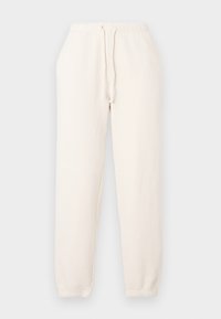 Krémové tepláky vyrobené z mäkkej látky. Majú elastický pás s šnúrkou a elastické manžety na členkoch.