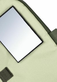 Pochette en tissu vert avec fermeture éclair, dotée d'un miroir rectangulaire réfléchissant intégré dans un cadre noir. Surface texturée et couture visible.