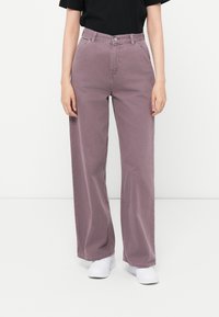 Pantaloni a vita alta e a gamba larga in cotone mauve polveroso con tasche anteriori. Presentano una chiusura con bottone e zip e un design semplice.