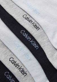 Βαμβακερές κάλτσες σε ανοικτό μπλε, γκρι και ναυτικό, με το λογότυπο "Calvin Klein" σε αντίθετους κλωστούς κατά μήκος των μανικιών.