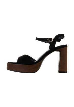 Sort ruskind platform sandal med chunky træblok hæl og justerbar ankrem med sølvspænde, sidevisning på hvid baggrund.