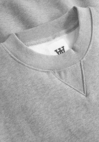 Gray sweatshirt with a crew neckline, textured fabric, and a reinforced v-stitch detail at the neck, featuring a stitched label inside.
