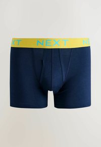 Tmavě modré bavlněné boxerkové šortky s žlutým elastickým pasem nesoucím nápis "NEXT" modrou barvou. Hladká textura, přiléhavý střih a střední délka.