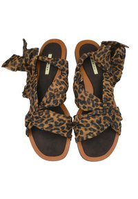 Sandalias de estampado de leopardo con cintas de tela que se enrollan en la parte delantera, plantillas marrones y suelas de goma marrón claro. Sin herrajes ni adornos.