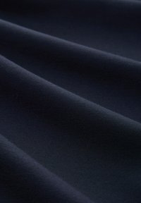 Tejido de un azul marino oscuro con una textura suave, que presenta pliegues sutiles y una superficie uniforme. No hay patrones ni detalles notables visibles.