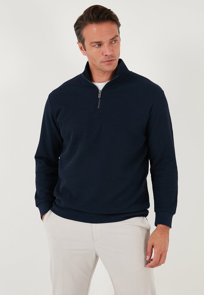 Navy ribbed pullover sweatshirt with a half-zip collar and long sleeves. Made of soft fabric, featuring a fitted waistband and cuffs.
