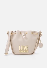 Beige hinkväska gjord av syntetiskt material med guldfärgade detaljer, utrustad med den präglade texten "LOVE MOSCHINO" och en fäst rund charm.