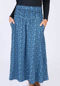 Lange Rock mit Blumenmuster in Blau, mit gerafftem Bund und Seitentaschen. Hergestellt aus leichtem Stoff mit einem fließenden Design.