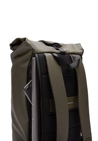 Sac à dos à rabat en olive et noir, comportant des bretelles robustes, une texture lisse, une poche latérale pour un ordinateur portable et un design compact.