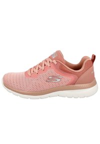 Zapatilla deportiva de color rosa claro con diseño de malla, cordones a juego, detalle sutil del logo y una suela blanca acolchada para mayor comodidad y soporte.