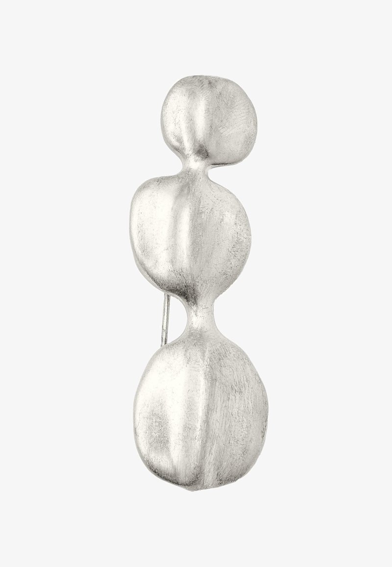 Silver metal brooch featuring an abstract design with three rounded shapes, smooth texture, and a subtle matte finish.