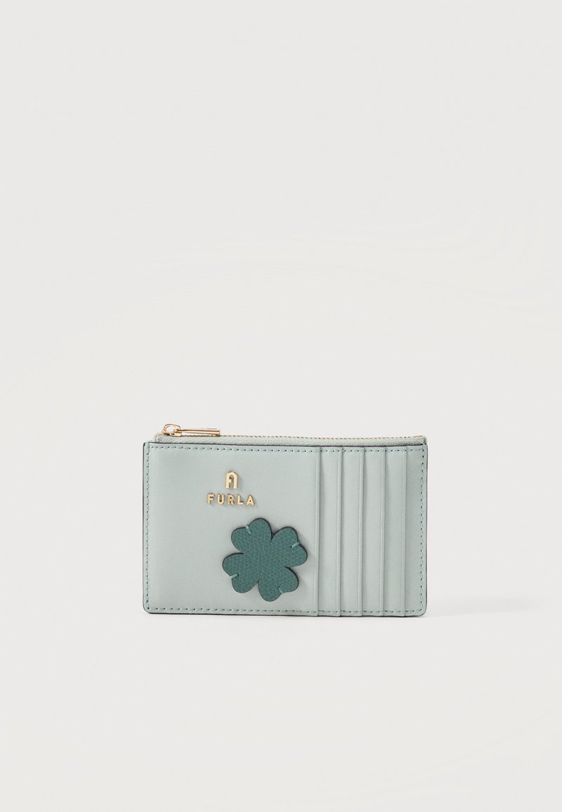 Porte-cartes bleu clair avec logo Furla doré, décoration trèfle vert foncé, six emplacements pour cartes et compartiment supérieur zippé.