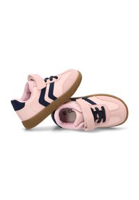 Zapatillas deportivas rosas con acentos en azul marino, que cuentan con una correa de Velcro, suelas de goma texturizadas y un diseño de punta redondeada.