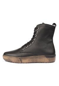Botas de tobillo de cuero negro con una suela de goma texturizada en tono marrón, con seis ojetes y una lengüeta trasera para facilitar su puesta.