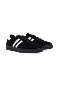 Czarne zamszowe sneakersy z białymi skórzanymi akcentami oraz trzema białymi paskami po bokach. Projekt obejmuje teksturowane sznurowadła oraz gumową podeszwę.