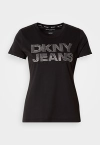 Svart t-skjorte laget av myk bomull, med korte ermer og rund hals, med "DKNY JEANS" trykt i metalliske detaljer på forsiden.