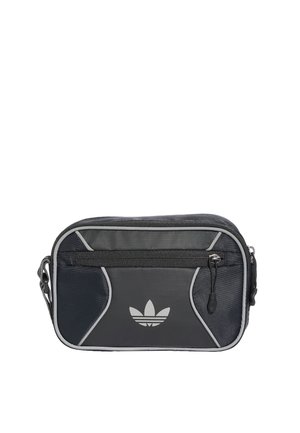 Mała czarno-szara torba na ramię Adidas z przednią kieszenią na zamek i logo na przednim panelu, na białym tle.