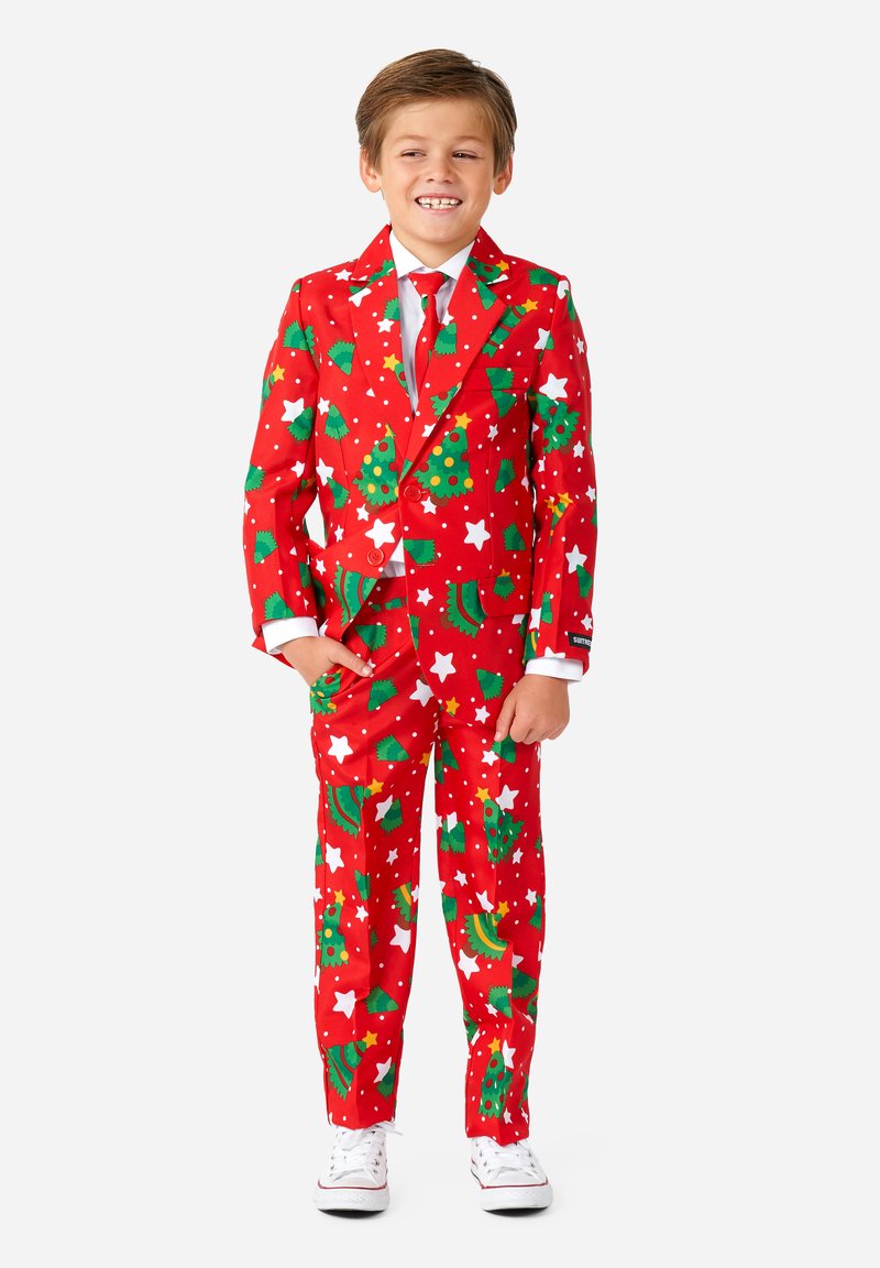 Completo rosso con motivi di albero di Natale, stelle e banane; pois bianchi; include una cravatta abbinata; abbinato a sneakers bianche.
