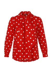 Blouse rouge à pois blancs, avec un nœud au col, manches longues et boutonnière, fabriquée en tissu lisse.