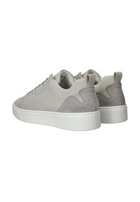 Grijze sneaker van suede en leer, met een witte rubberen zool, ronde neus en een kleine hieltab aan de achterkant.
