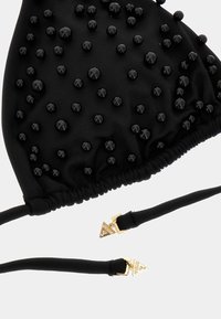Black bikini top with textured fabric featuring glossy black beads, gathered design, adjustable straps, and gold hardware accents.