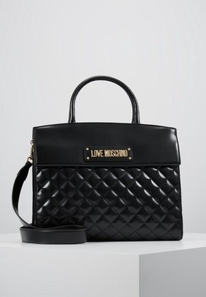Czarna pikowana torebka Love Moschino z górnymi uchwytami i odpinanym paskiem na ramię, przedstawiona na białej powierzchni.