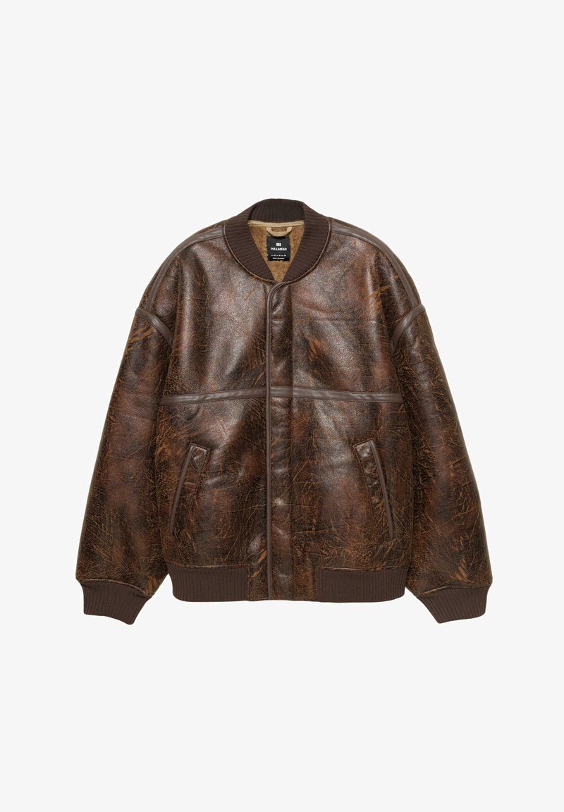 Barna, hasított bőr bombázó dzseki bordázott gallérral, mandzsettákkal, aljjal és két elülső zsebbel, fehér háttérre fekve.