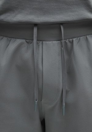 Grå mjukisbyxor med elastisk midjeresår och dragsko. Har mjuk tygstruktur, sydda detaljer och framfickor.