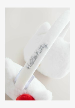 Bílé plyšové pantofle s měkkou strukturou, s červeným akcentem a stříbrnou výšivkou "Hello Kitty" na pásku. Kulatý design.