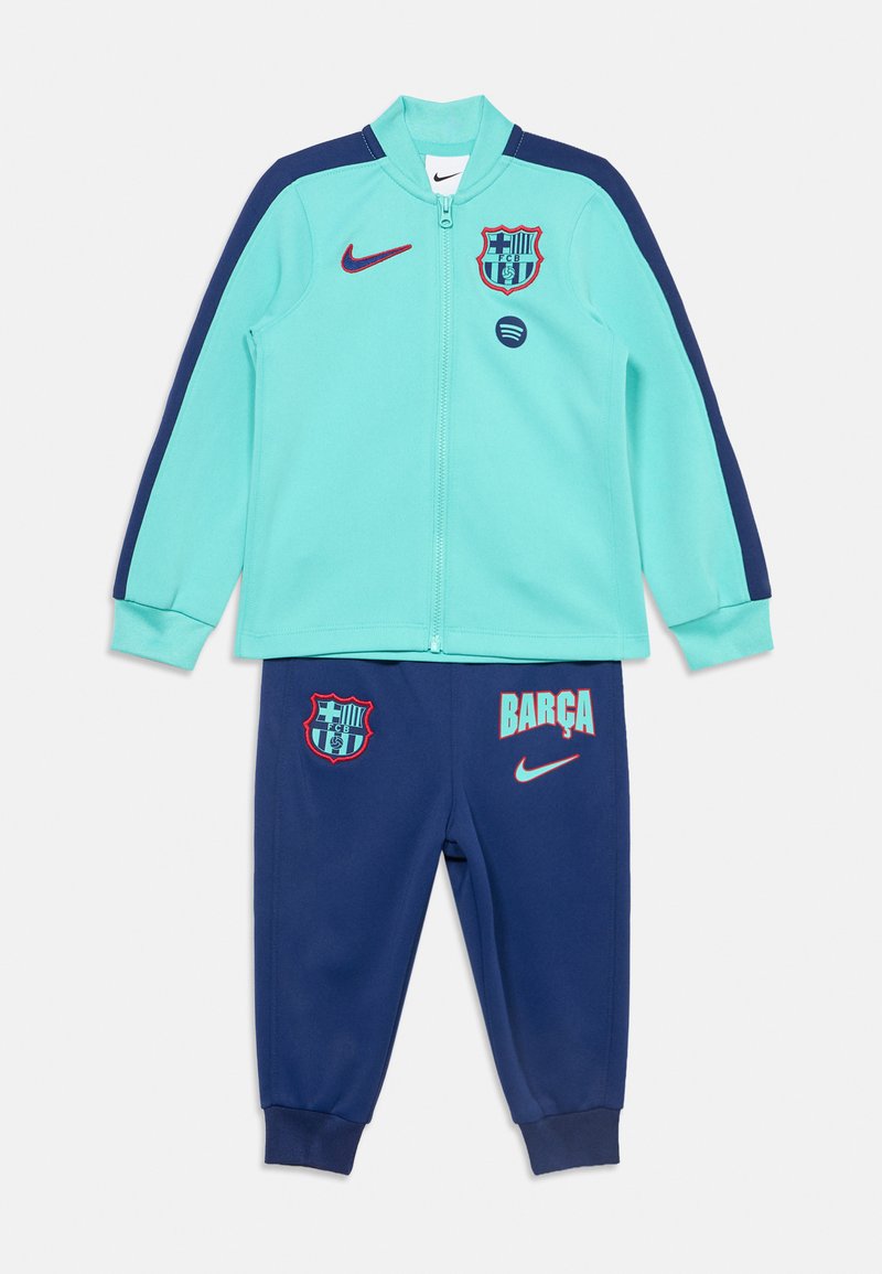Ανοιχτό μπλε και ναυτικό μπλε φόρμα Nike Barcelona με ζακέτα με φερμουάρ και παντελόνι, με λογότυπα συλλόγου και το κείμενο "BARÇA".